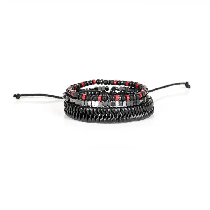 Black multi-layer men’s bracelet featuring glossy black disc beads, metallic hematite cube beads, matte black accents, and red bead details with adjustable cord closure on a light background.