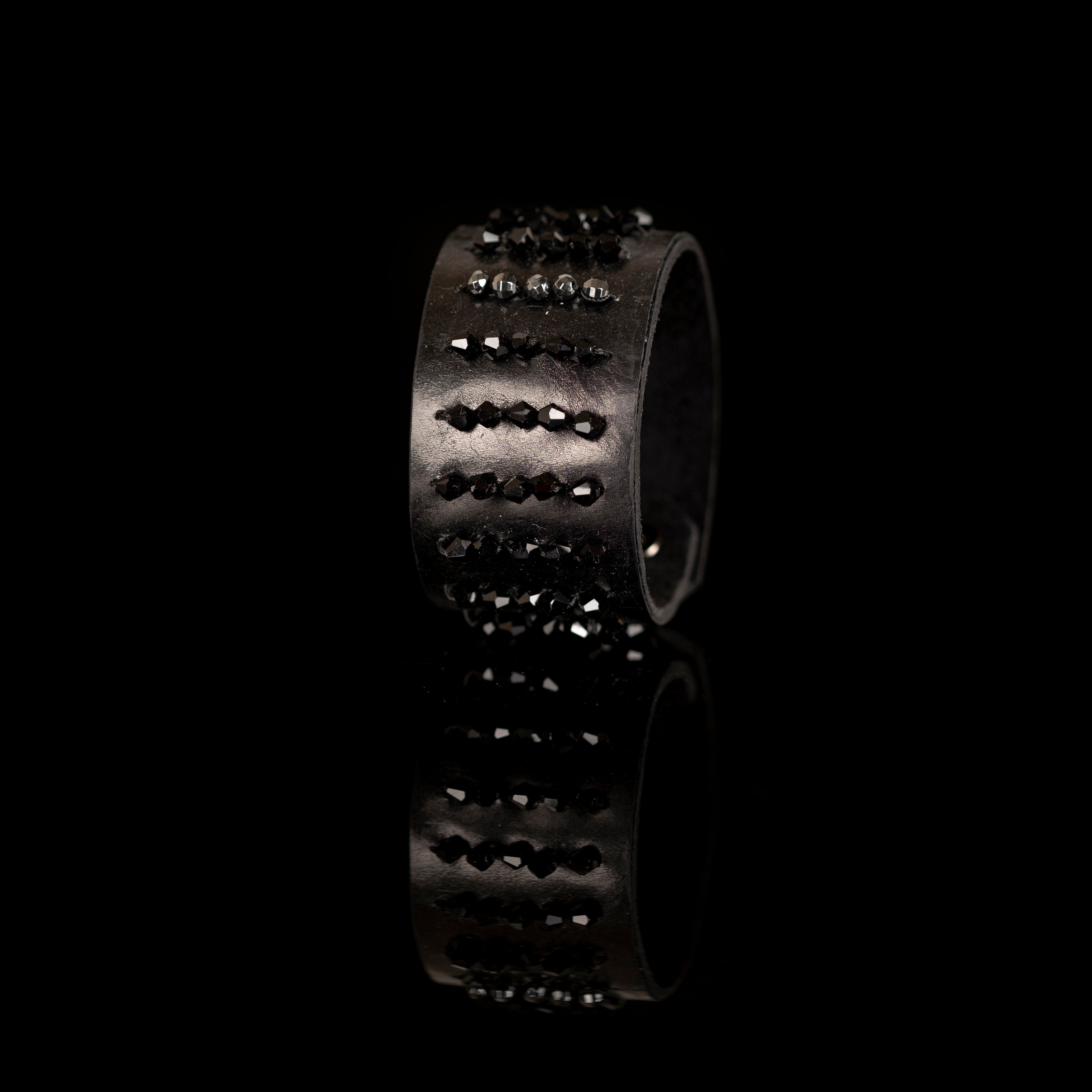 Black leather cuff bracelet with horizontal rows of faceted black crystals and metallic beads, handmade statement bracelet by THE DARK