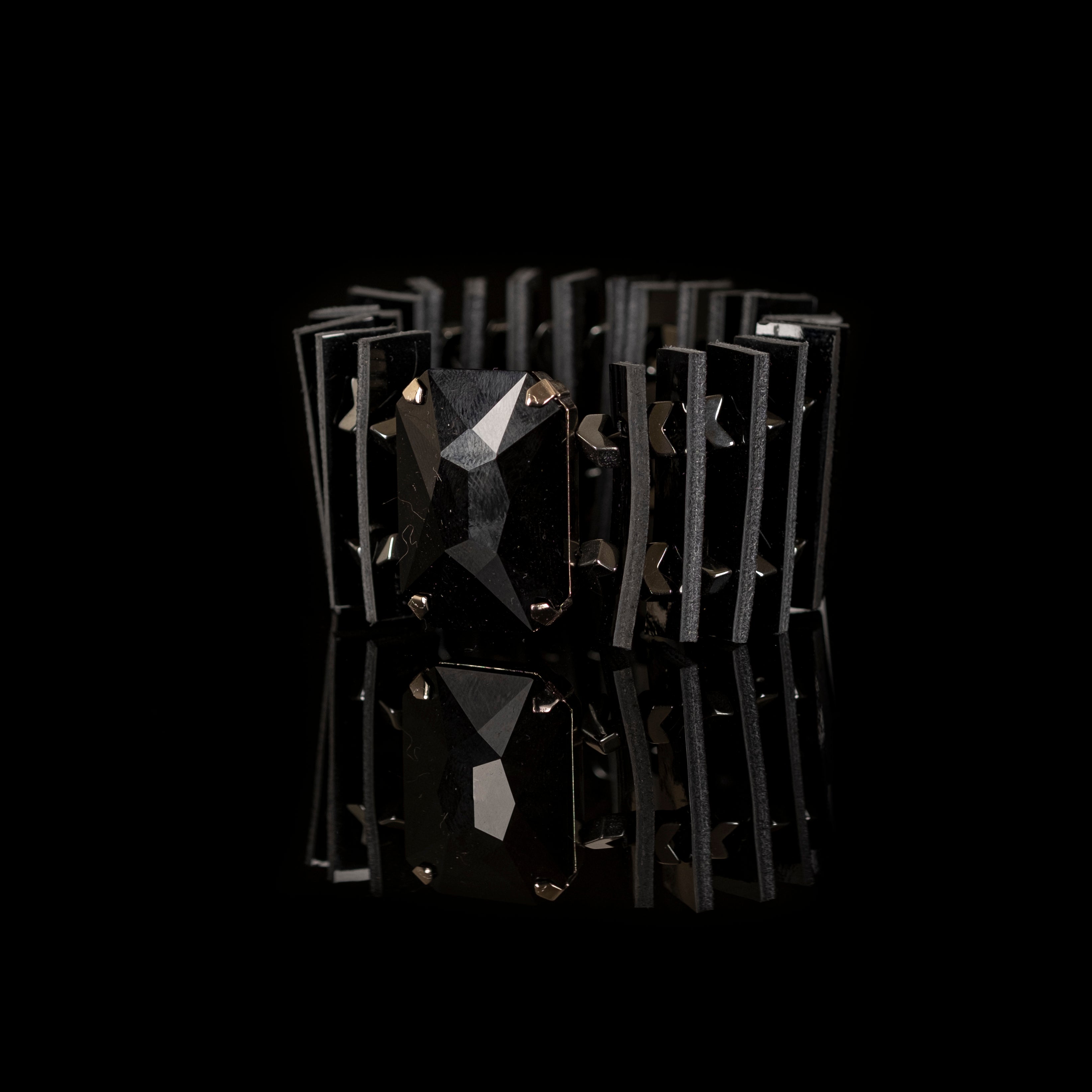 Black leather sculptural bracelet with large faceted black crystal and layered geometric leather panels, handmade statement bracelet by THE DARK