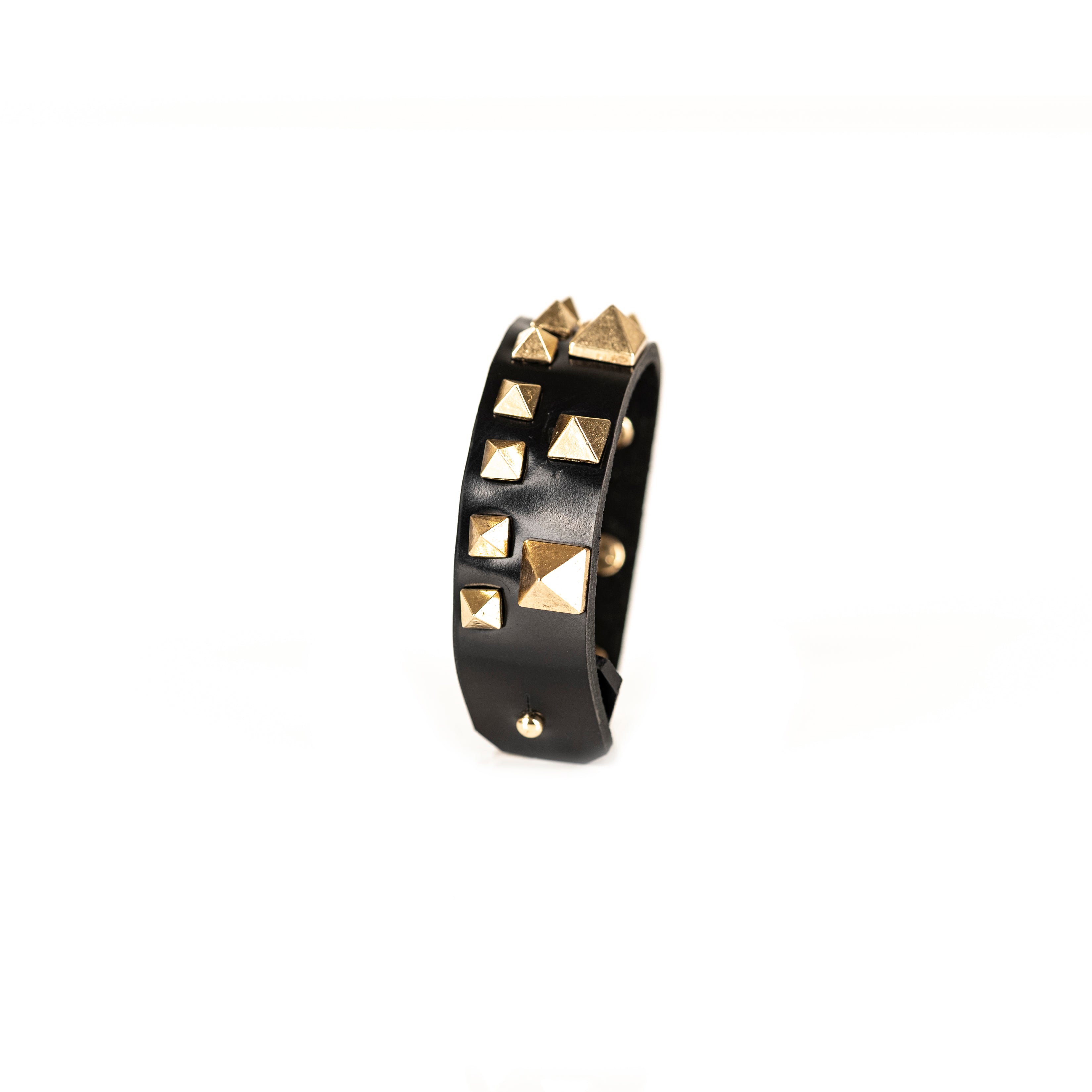 Black leather cuff bracelet with gold pyramid studs and geometric metal details, handmade statement bracelet by THE DARK
