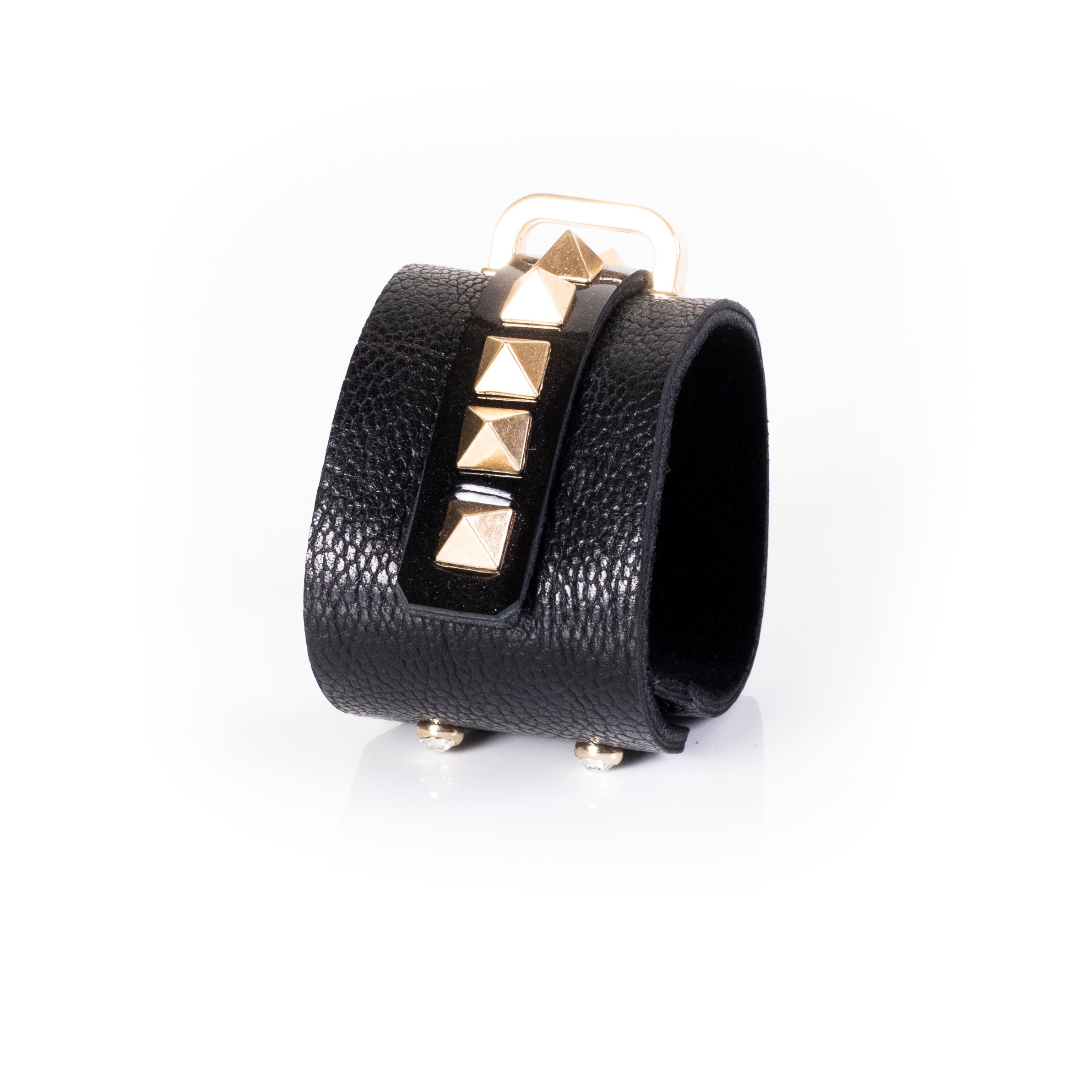 Black leather wrap cuff bracelet with gold pyramid studs, central glossy strip and gold buckle detail, handcrafted statement bracelet for women by THE DARK