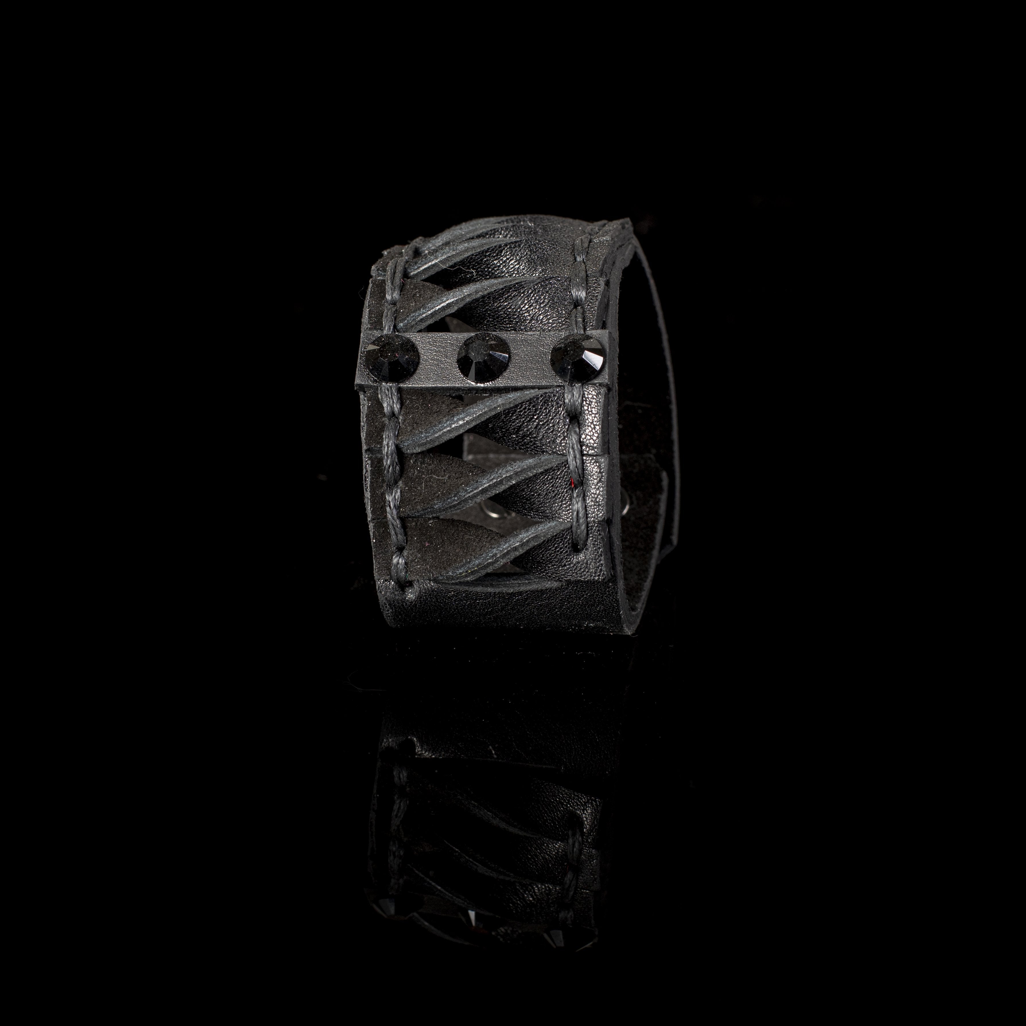 Handmade black leather cuff bracelet featuring lace-up detailing and faceted black crystals in a gothic statement design for men.
