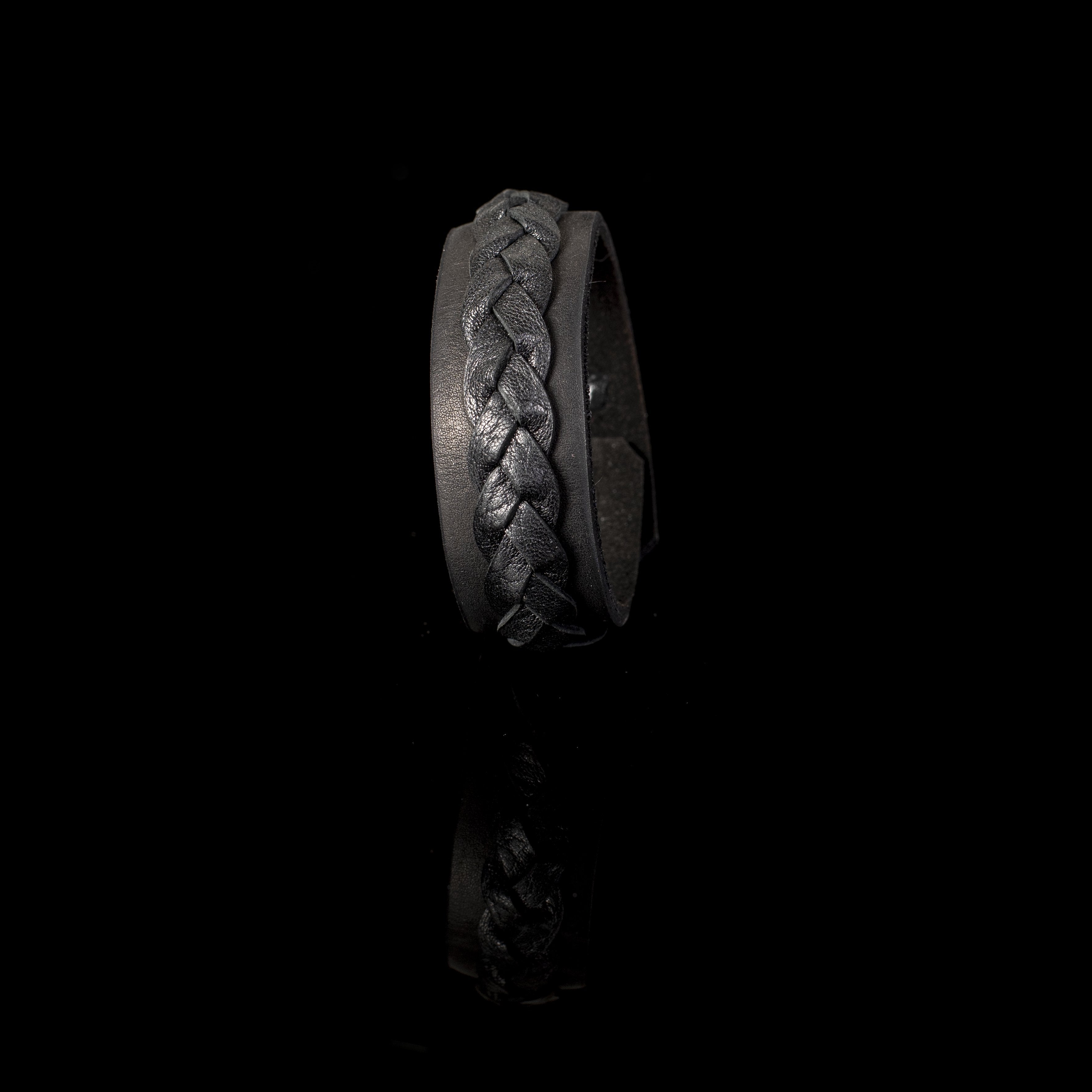 Handmade black leather cuff bracelet featuring a raised braided leather detail on a wide leather band.