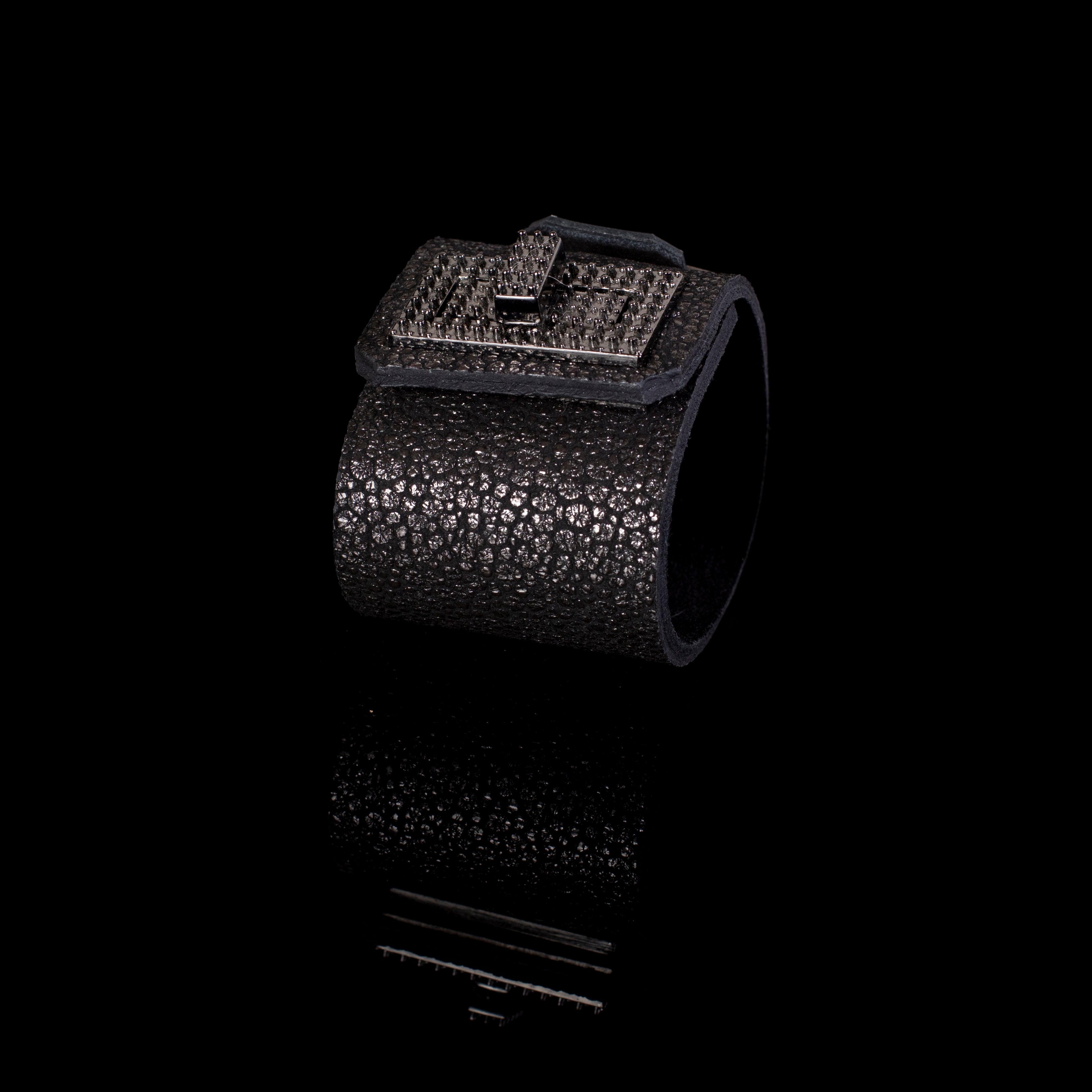 Black textured leather cuff bracelet with square studded plate and metallic clasp detail, bold statement bracelet for women