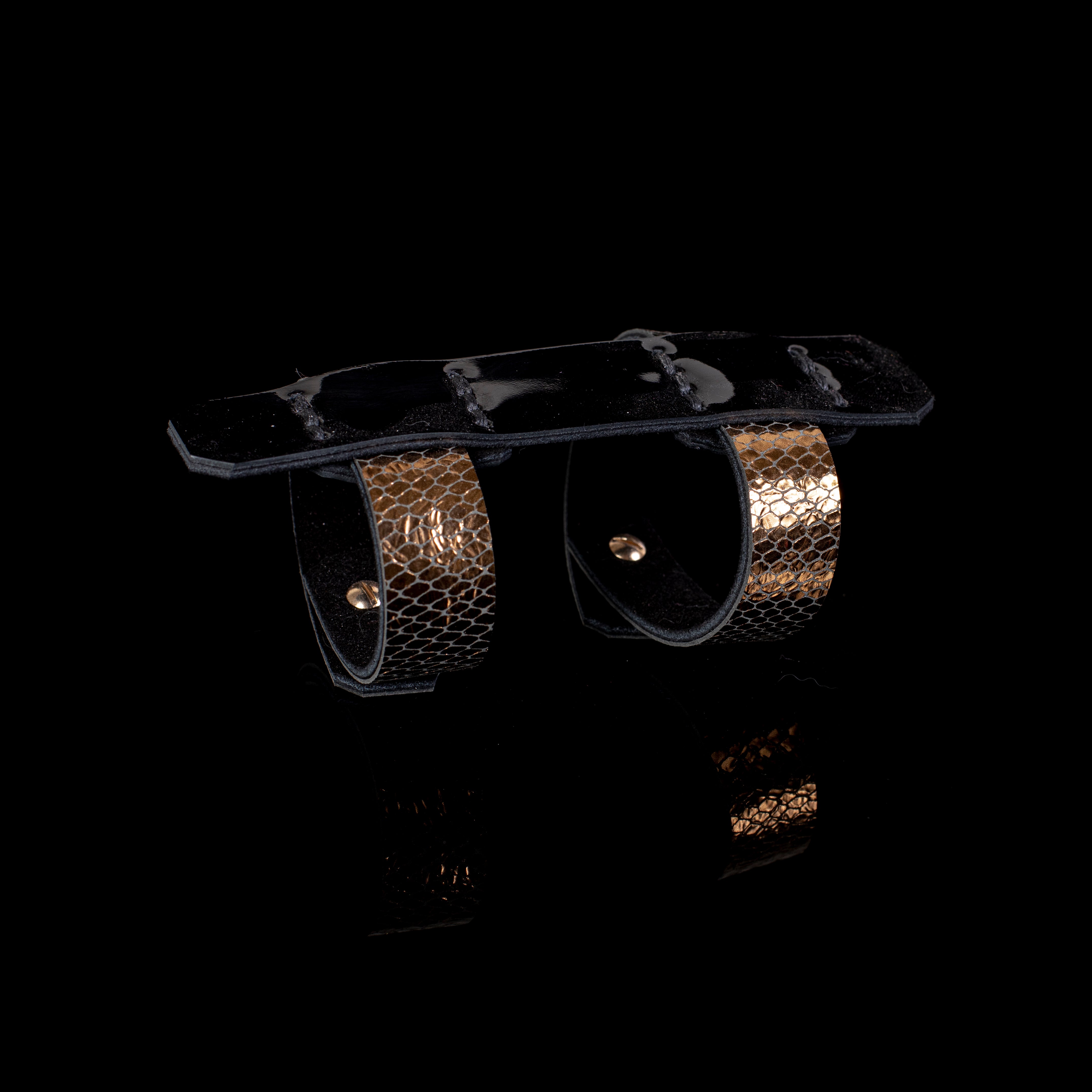 Black leather sculptural cuff bracelet with double ring design and gold python textured bands, handcrafted architectural statement bracelet for women by THE DARK