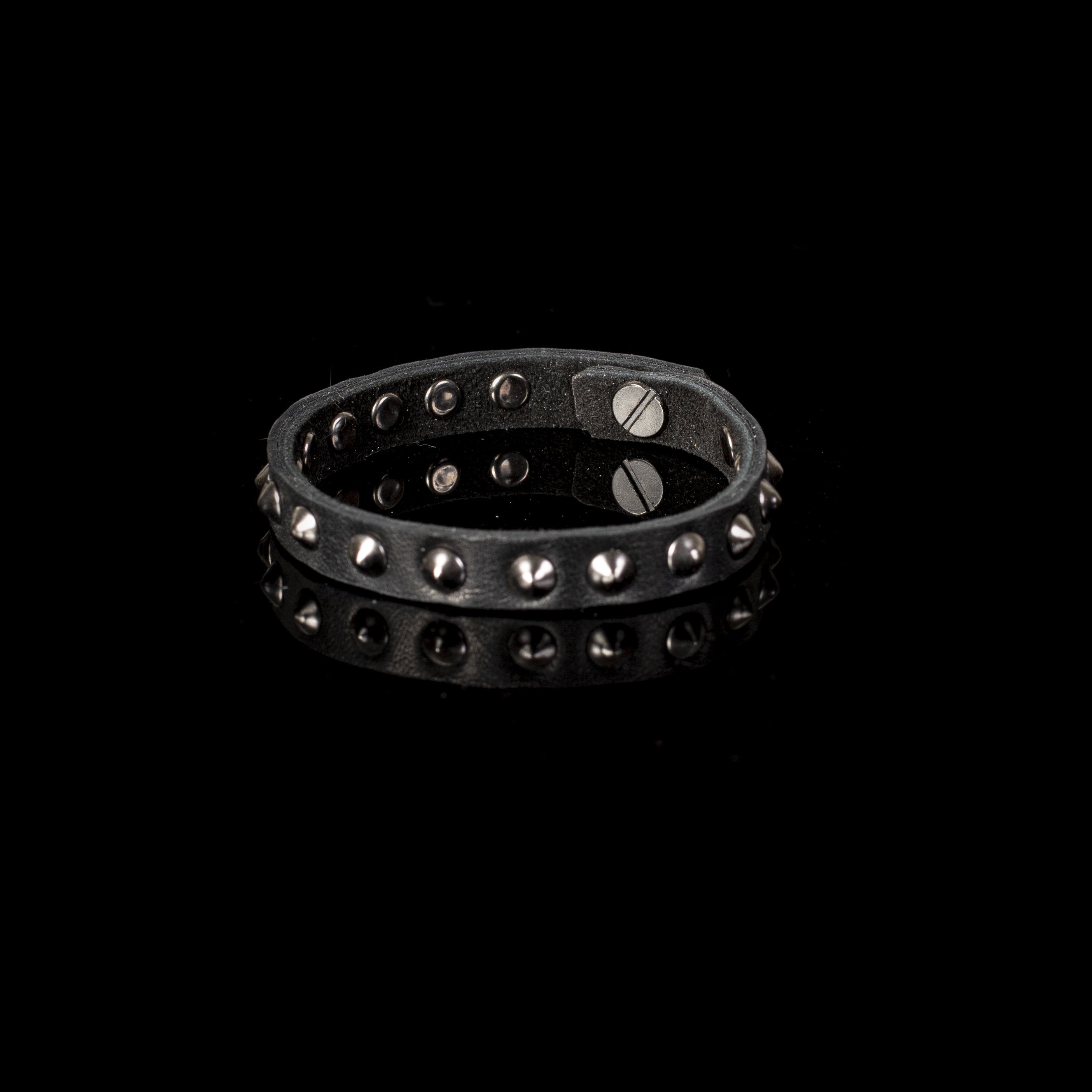 Handmade black leather bracelet with dark cone studs and adjustable snap closure for men.