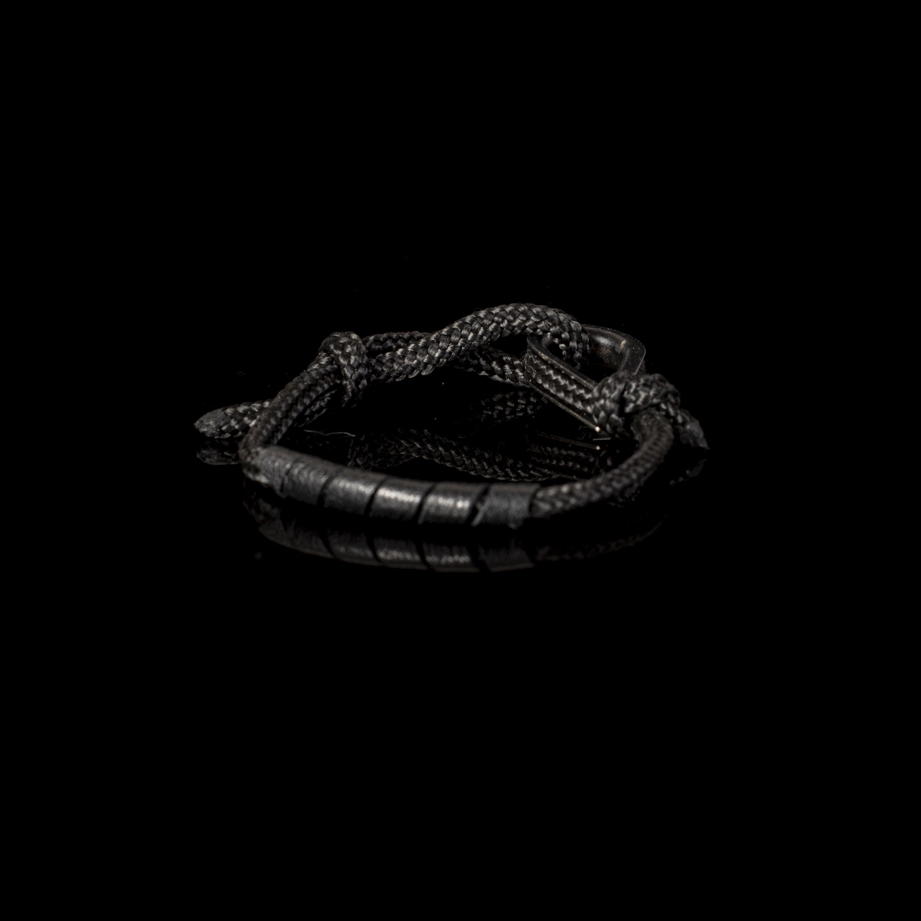 Handmade black rope bracelet featuring black leather accents and a black hook clasp closure in a minimalist nautical-inspired design.