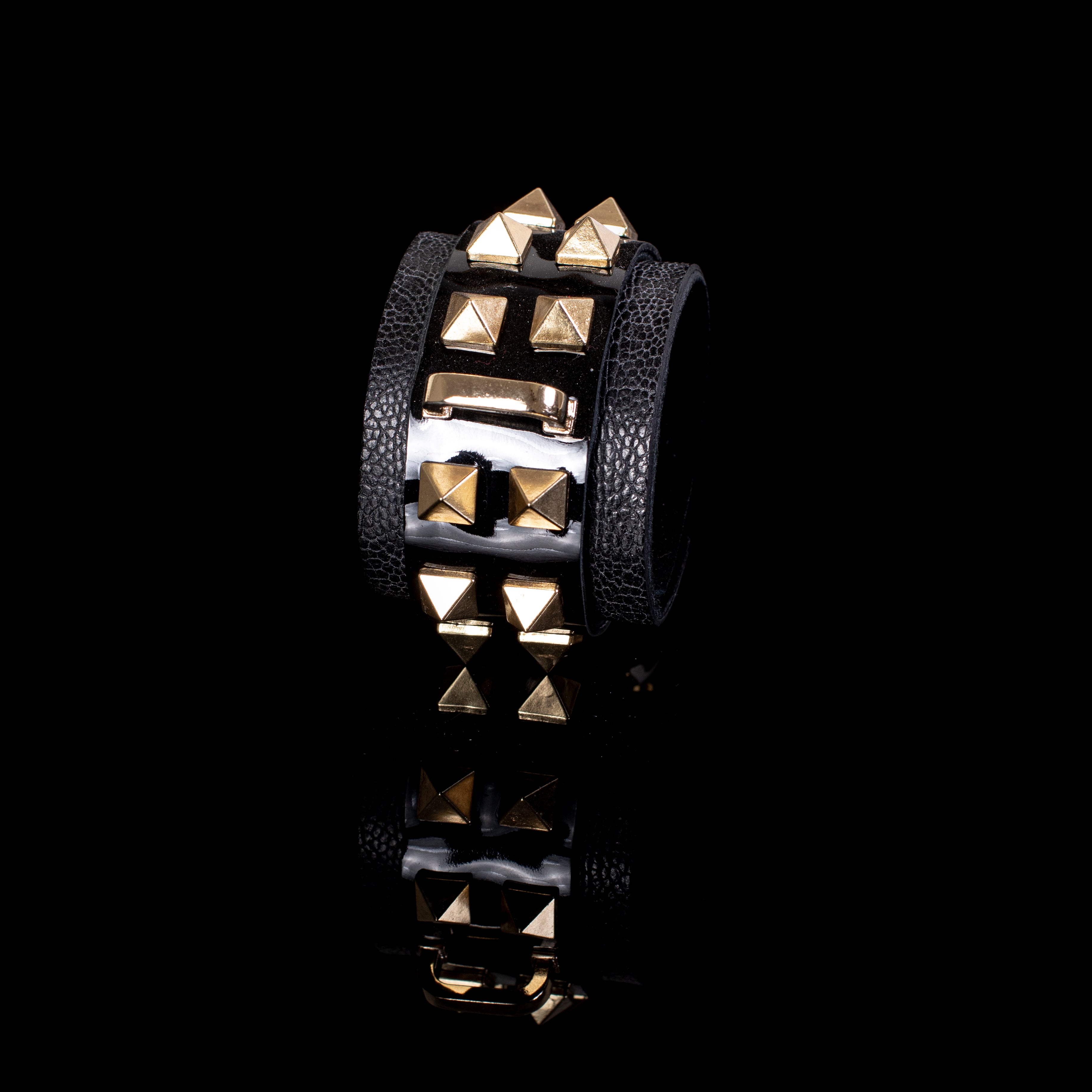 Black patent leather cuff bracelet with gold pyramid studs and textured leather side panels, wide handcrafted statement bracelet for women by THE DARK