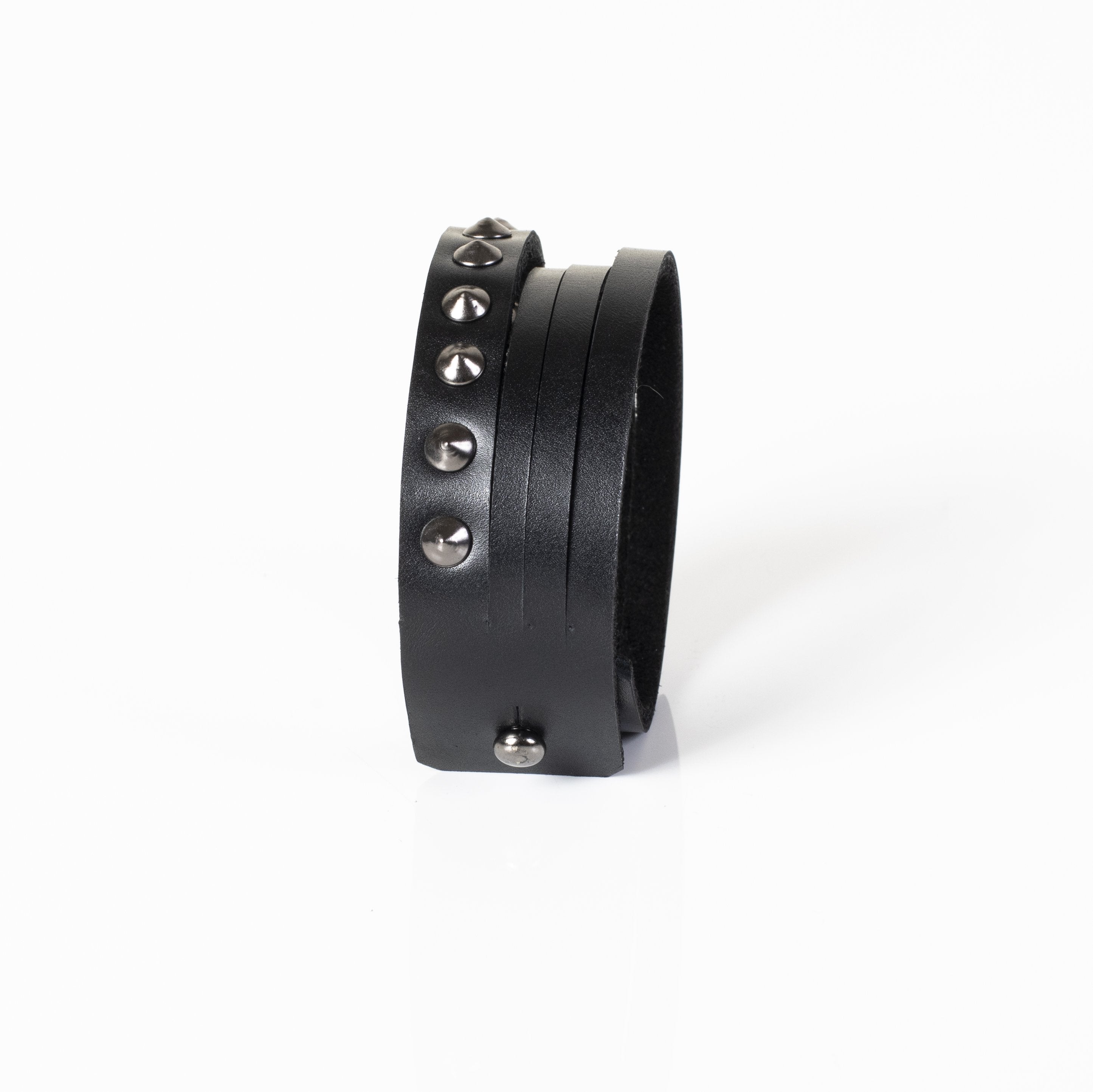Men's multi-layer black genuine leather bracelet featuring gunmetal rivets, studded detailing, and adjustable snap-button closure on a white background.