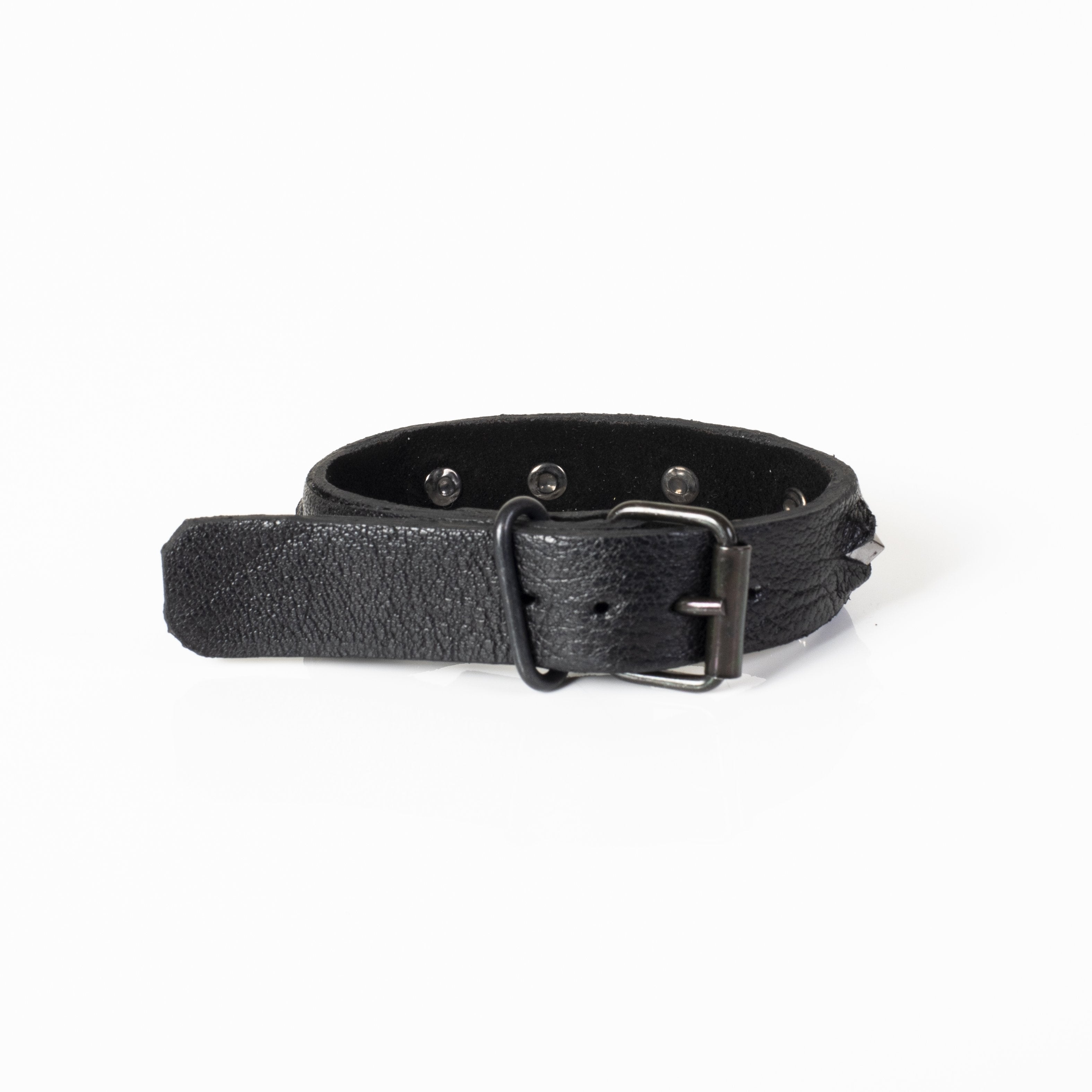 Men's black leather cuff bracelet featuring gunmetal pyramid studs and adjustable snap-button closure on a white background.