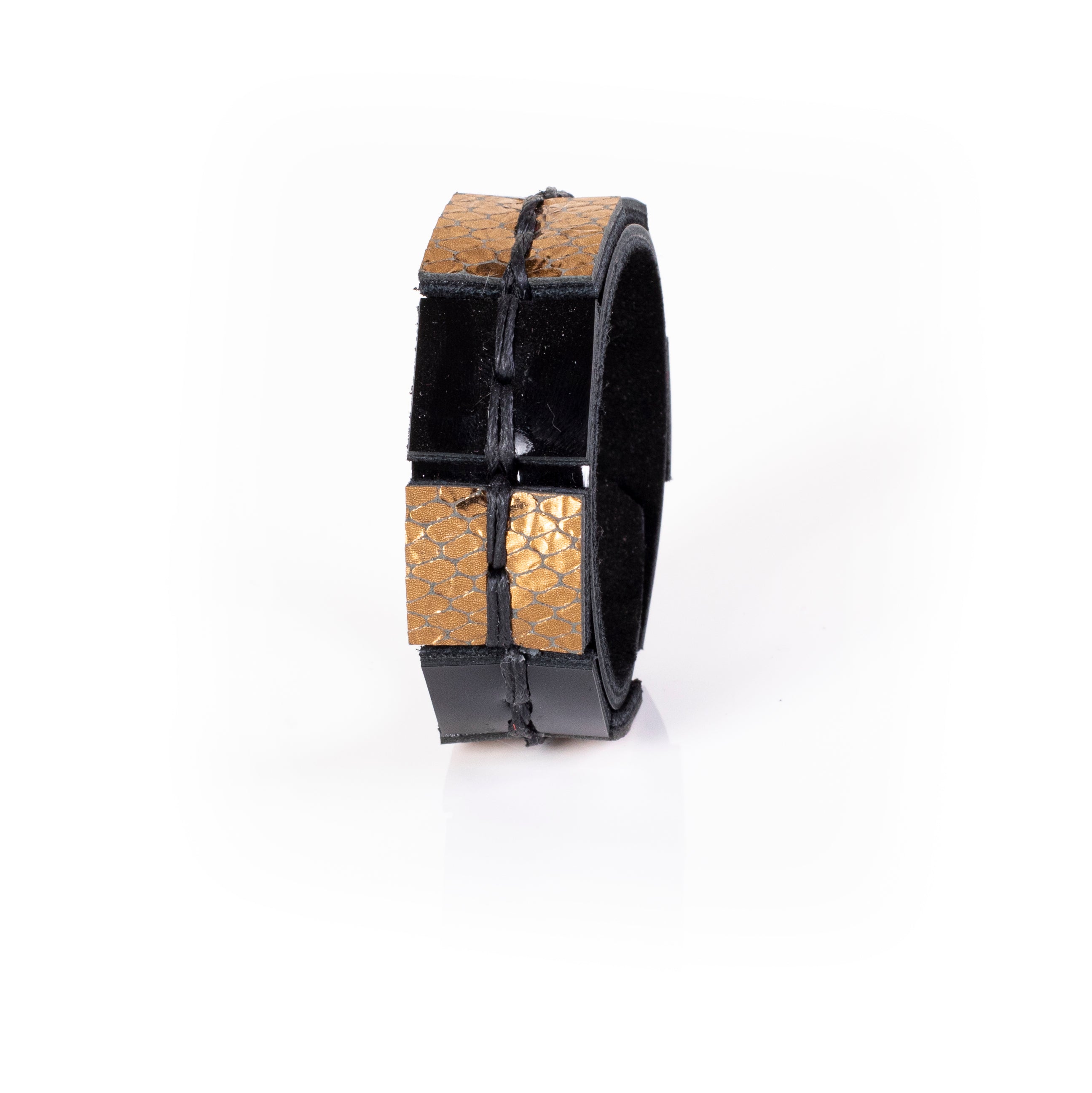 Black leather cuff bracelet with gold python textured panels and visible hand stitching, handcrafted structured statement bracelet for women by THE DARK