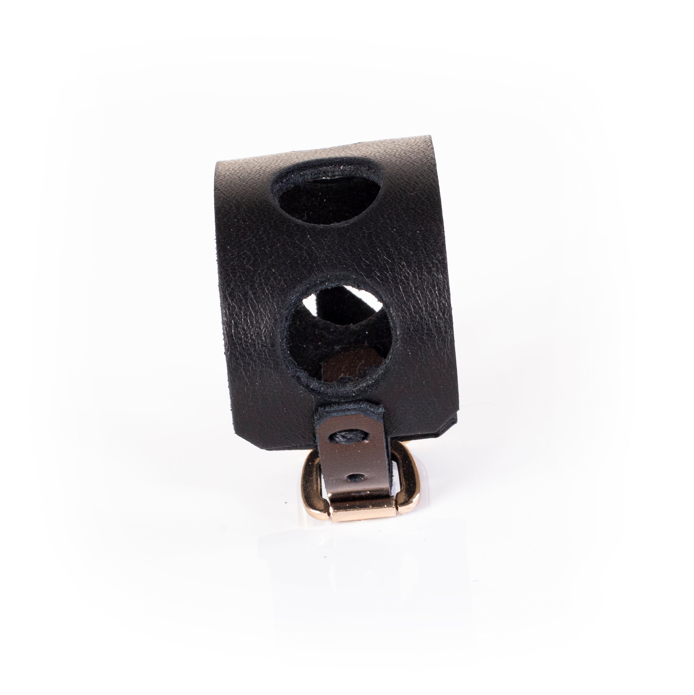 Wide black leather cuff bracelet with circular cutout design and gold buckle closure, minimalist handcrafted statement bracelet for women