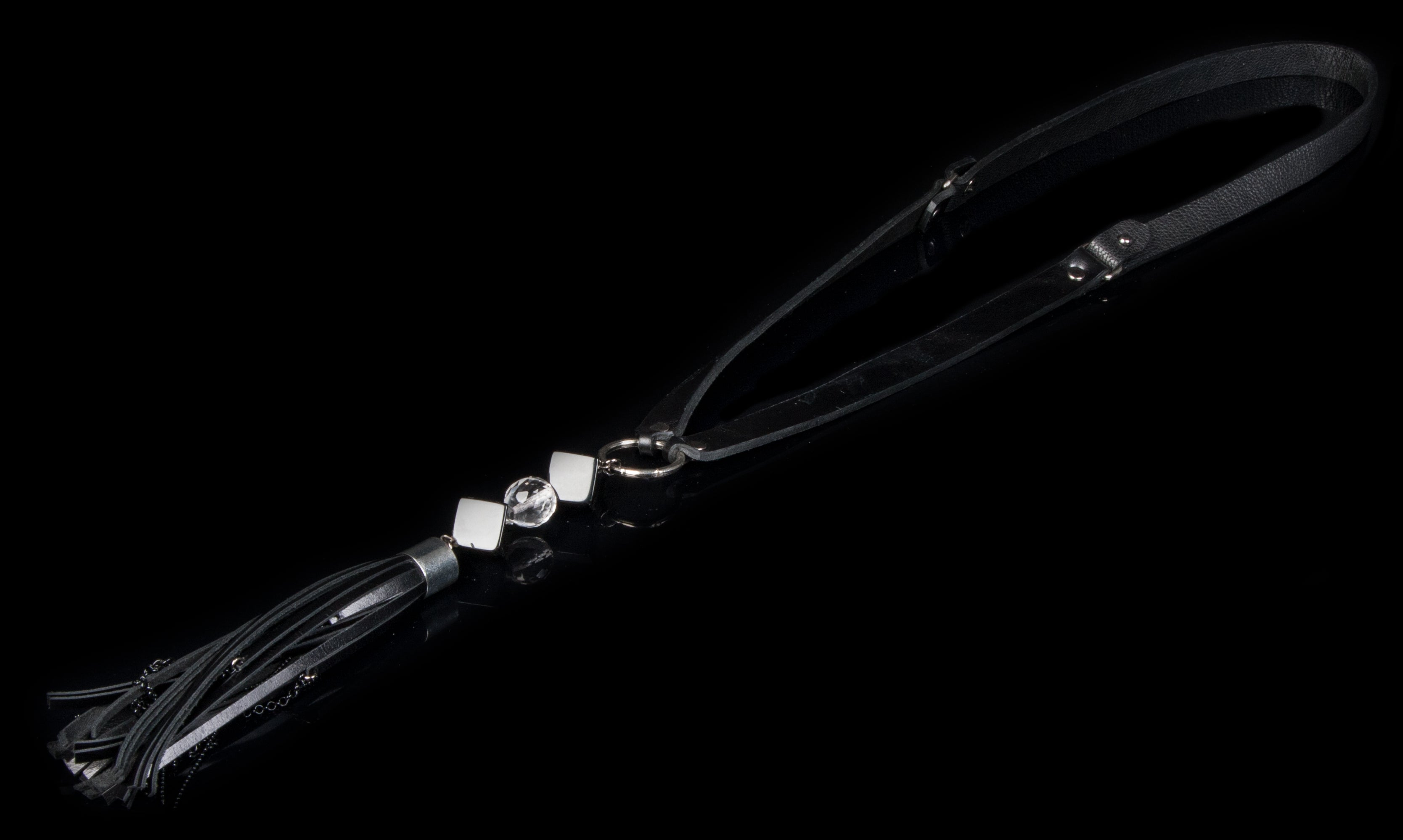 Handmade black leather necklace with long tassel pendant and black geometric bead accents on white background