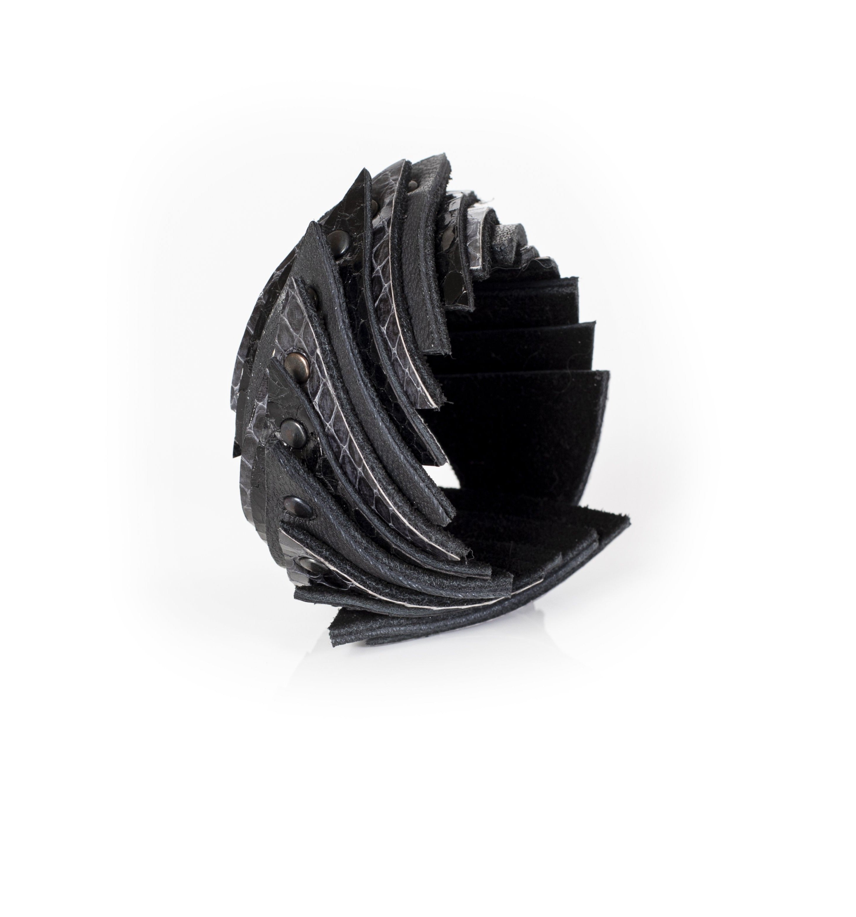 Black layered leather cuff bracelet with curved segmented structure and stud details, sculptural statement bracelet for women