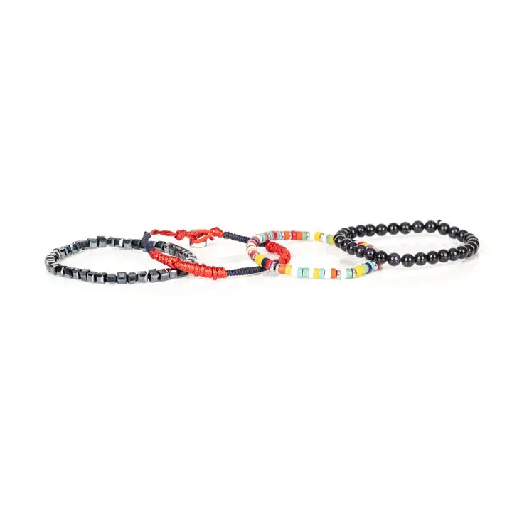 Men’s layered bracelet set featuring glossy black onyx-style beads, multicolor seed beads, red woven cord, navy braided cord, and faceted hematite cube beads, stacked in a bold contemporary luxury design on a white background.