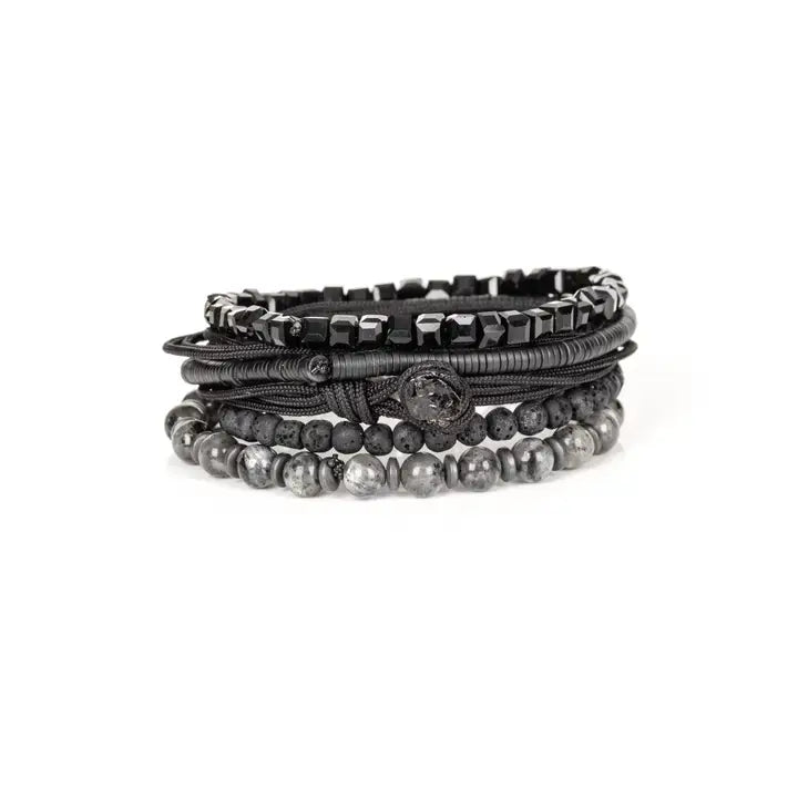 Men’s layered bracelet set featuring black faceted crystal beads, matte black lava stone beads, black braided cord, hematite spacer beads, and polished gray stone beads, stacked in a bold monochromatic luxury design on a white background.