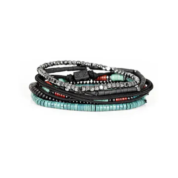 Black multi-layer men’s bracelet featuring hematite bead strands, braided rope layers, turquoise and red accent beads, geometric black centerpiece, and layered metallic details on a light background.