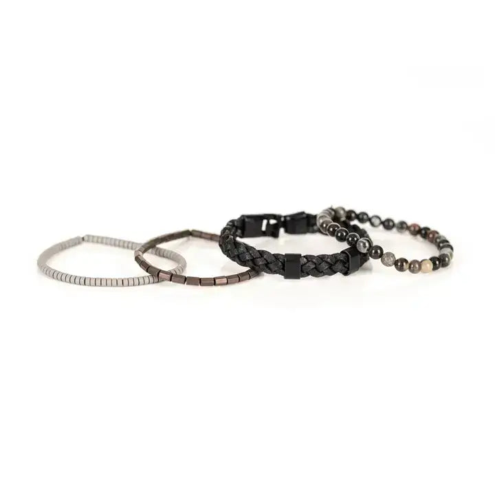 Black multi-layer men’s bracelet set featuring braided leather band, smoky grey natural stone beads, hematite cube accents, and layered metallic bead strands on a light background.