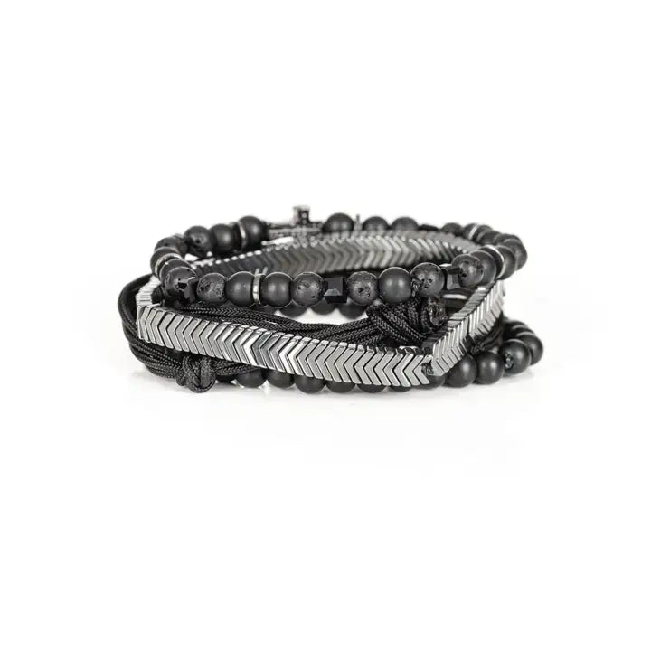 Black and silver layered men’s bracelet set with matte black beads, silver chevron metal bar, pavé cross detail, and braided rope wraps on white background.
