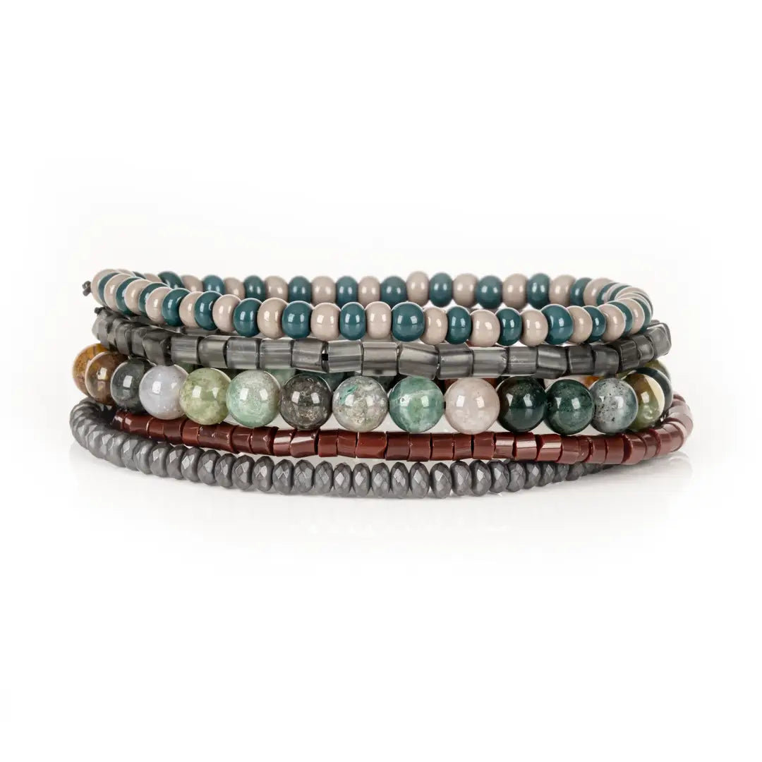 Men’s layered bracelet set featuring teal and beige bead strands, smoky gray translucent beads, multicolor natural stone beads in green, cream, and earth tones, reddish-brown heishi beads, and faceted hematite spacer beads, stacked in a sophisticated earthy luxury design on a white background.