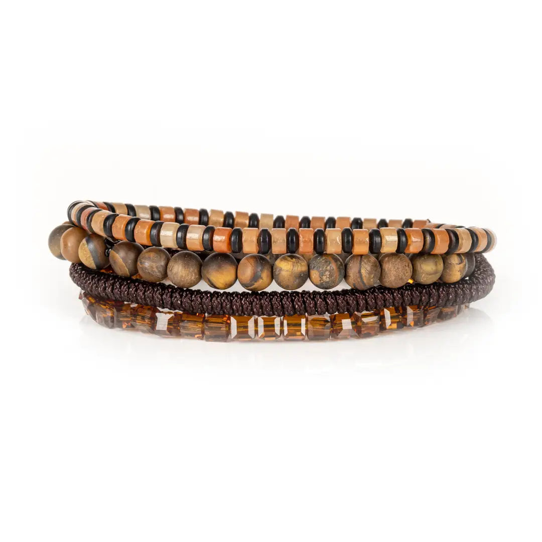 Men's layered bracelet set featuring genuine Tiger Eye stone beads, amber crystal accents, earth-tone heishi beads, and brown woven cord details arranged in a stacked design on a white background.