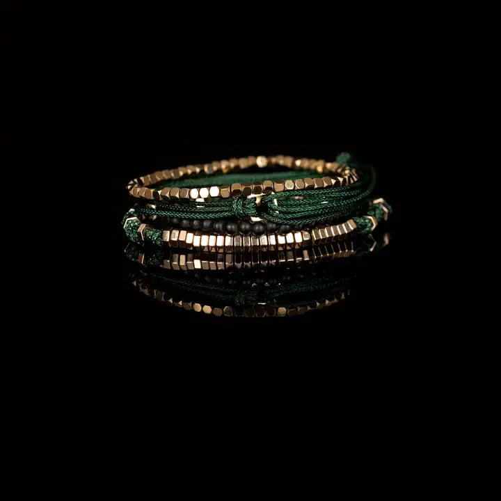 Men’s layered bracelet set featuring gold-tone faceted metal beads, dark green braided cord wraps, matte black bead accents, and gold-tone geometric spacer beads, stacked in a sophisticated green and gold luxury design on a white background.