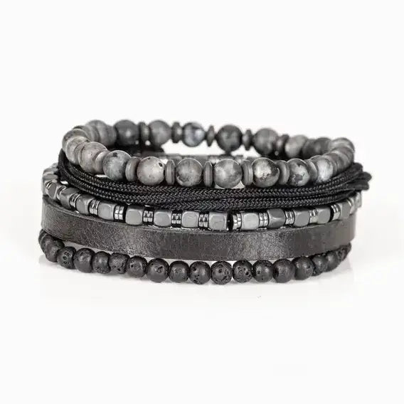 Men’s layered bracelet set featuring gray marbled natural stone beads, a black leather cuff, matte black lava stone beads, black braided cord, hematite cube beads, and metallic spacer accents, stacked in a sophisticated monochromatic luxury design on a white background.