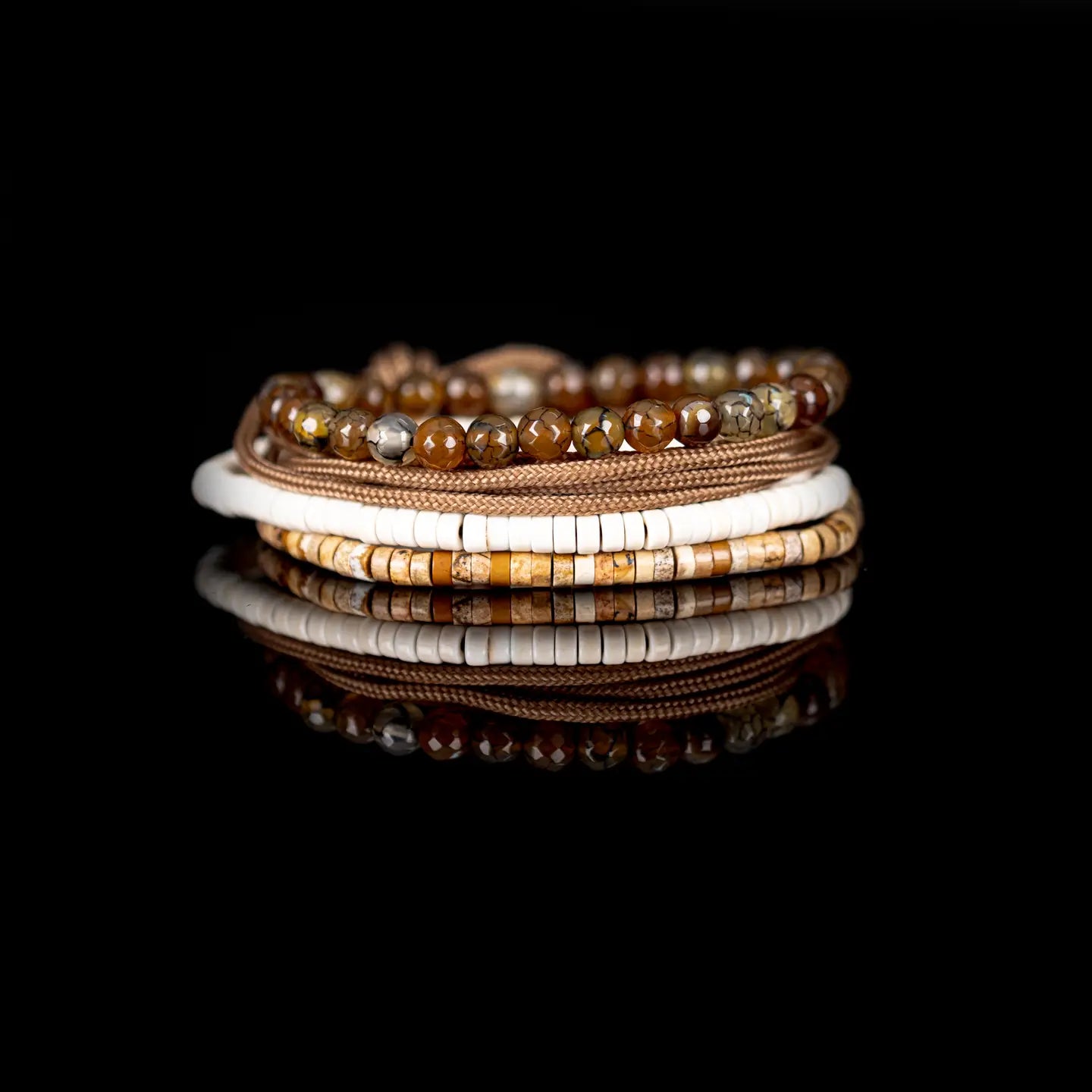Men’s layered bracelet set featuring faceted brown crackle agate beads, tan braided cord wraps, white heishi beads, and natural earth-tone stone disc beads, stacked in a refined bohemian luxury design on a white background.