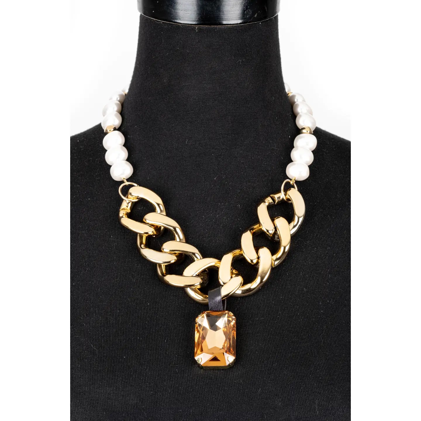 Gold chunky chain necklace with pearl detail and amber crystal pendant on white background.
