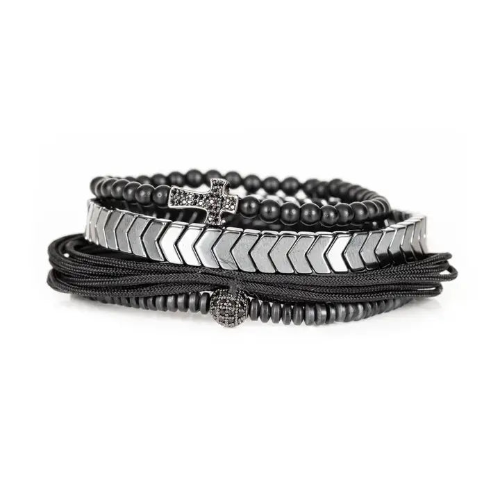 Black and silver layered men’s bracelet set with pavé cross detail, silver chevron metal strand, matte black beads, braided rope wraps, and pavé accent bead on white background.
