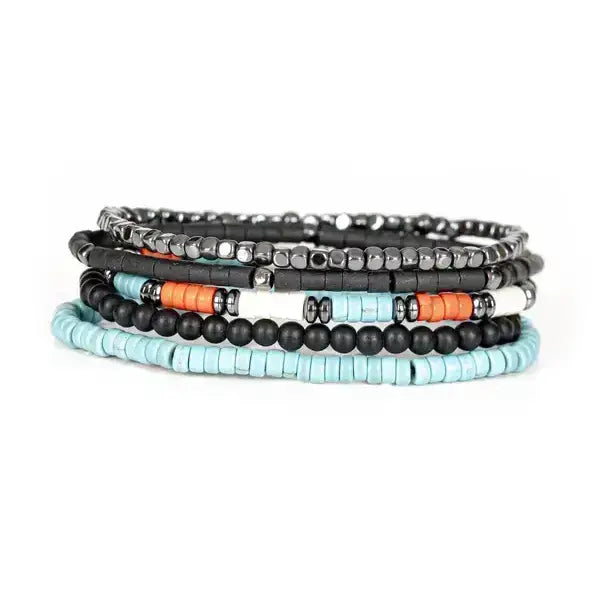 Black multi-layer men’s bracelet featuring hematite cube bead strands, matte black onyx beads, turquoise disc beads, and orange accent details on a light background.