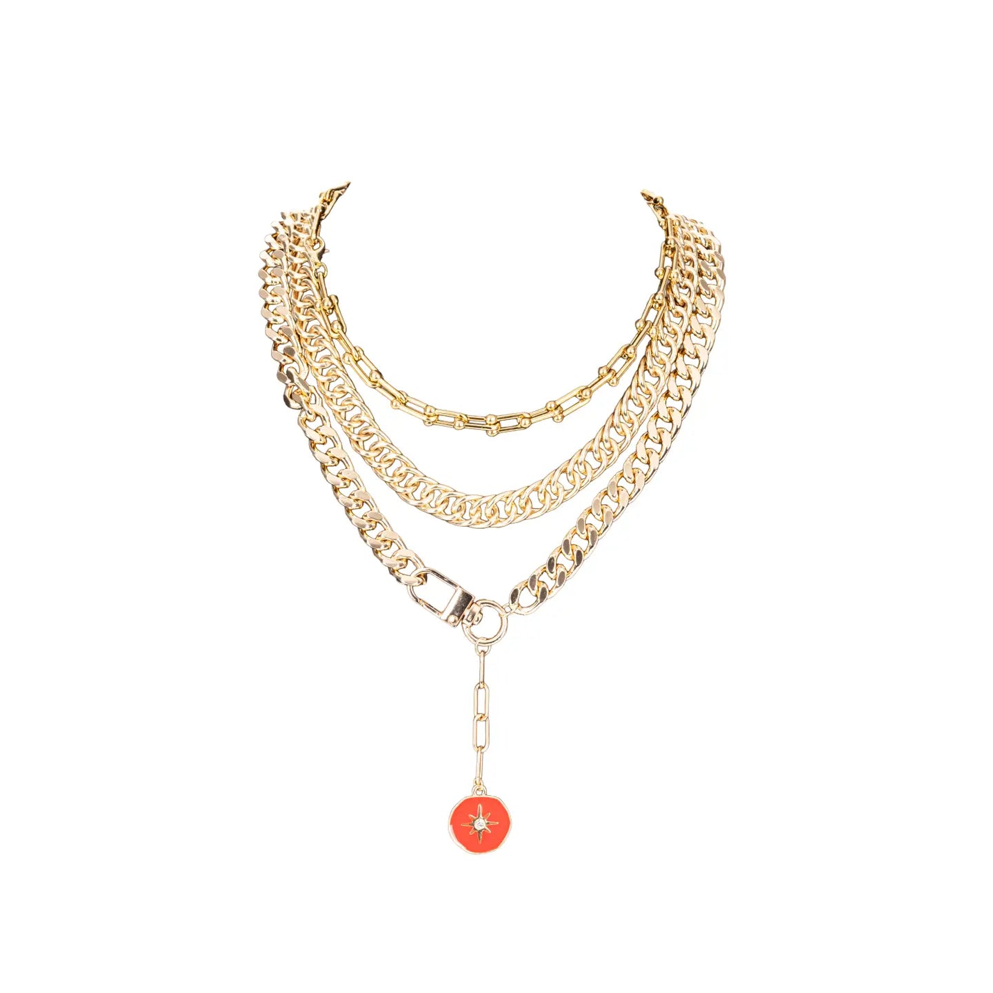 Layered gold chain necklace with multiple chain styles and a red enamel charm drop, displayed on a white background.