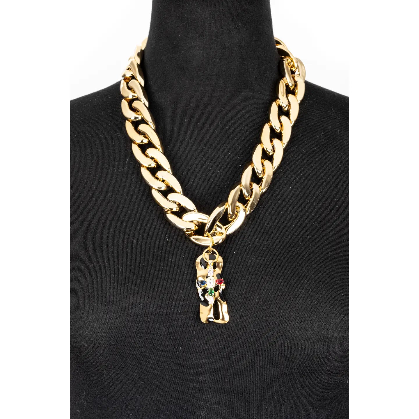 Gold chunky chain necklace with sculptural abstract pendant and subtle crystal accents on white background.