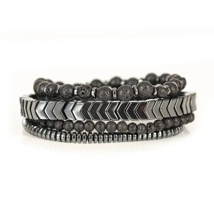 Black multi-layer men’s bracelet set featuring lava stone beads, silver chevron metal bar, hematite spacer beads, and layered metallic accents on a light background.