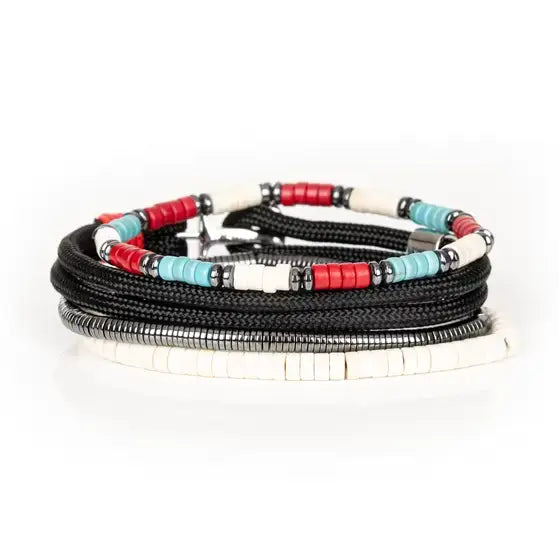 Men’s layered bracelet set featuring black braided cord, white heishi beads, turquoise and red disc beads, silver-tone accents, and hematite spacer beads, stacked in a contemporary bohemian luxury design on a white background.
