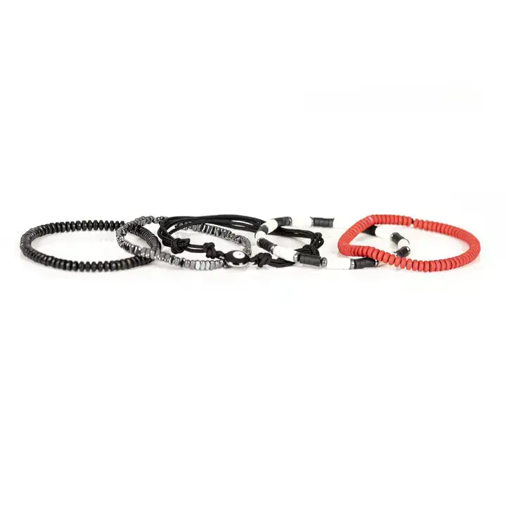 Men’s layered bracelet set featuring coral-red heishi beads, black braided cord wraps, black and white accent beads, faceted hematite crystal beads, black heishi beads, and an evil eye centerpiece, stacked in a bold contemporary bohemian luxury design on a white background.