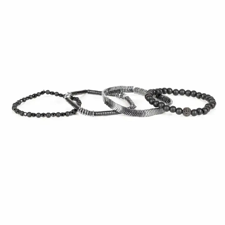 Black multi-layer men’s bracelet featuring matte black onyx beads, silver chevron metal bar, faceted black crystal beads, pyramid-cut hematite accents, and layered metallic details on a light background.