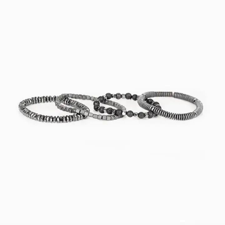 Men’s layered bracelet set featuring silver-tone coil wrap beads, matte black lava stone beads, polished hematite cube beads, faceted hematite crystal beads, and metallic spacer accents, stacked in a sleek industrial luxury design on a white background.