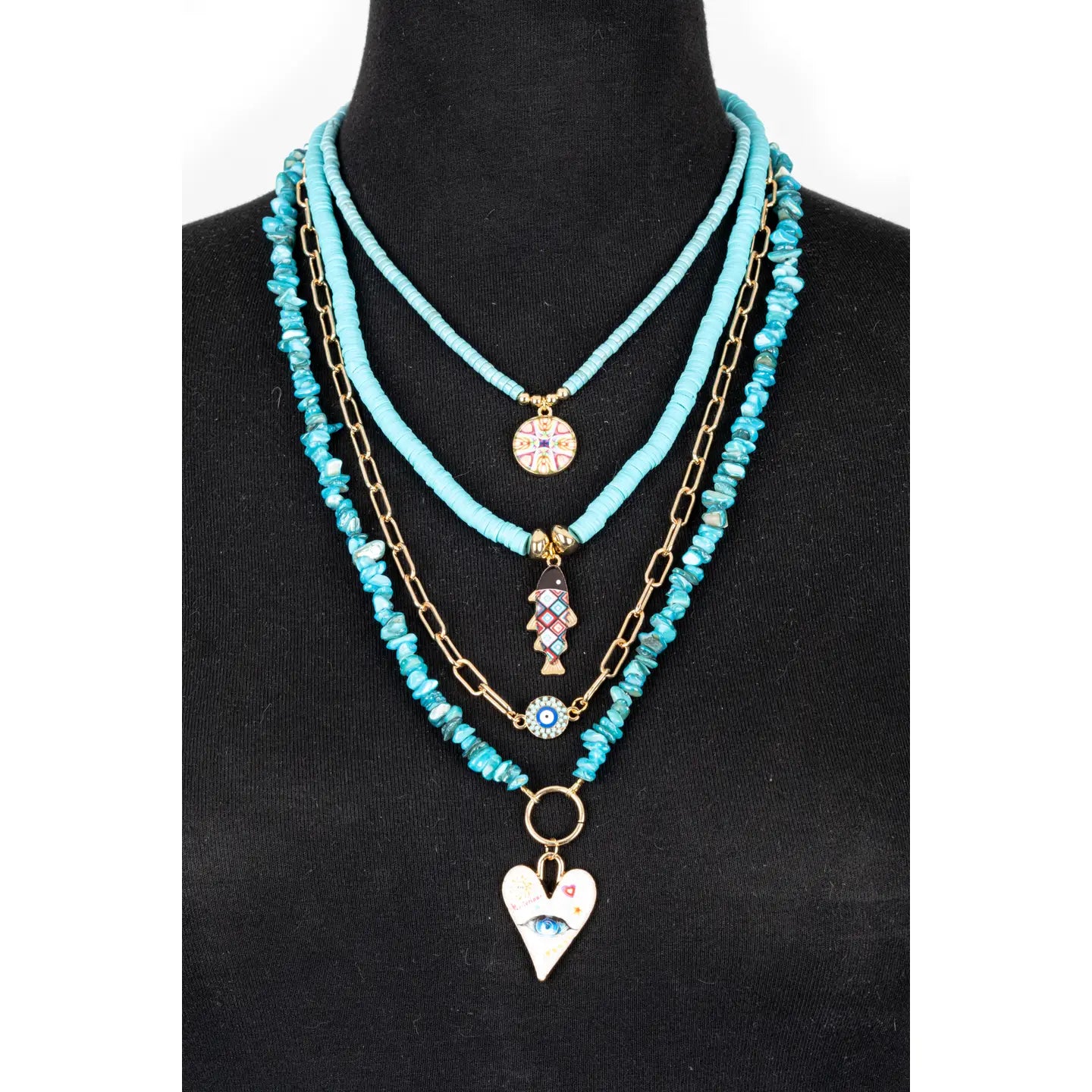 Layered turquoise beaded necklace with multiple strands, gold chain accents, and charm pendants, displayed on a white background.