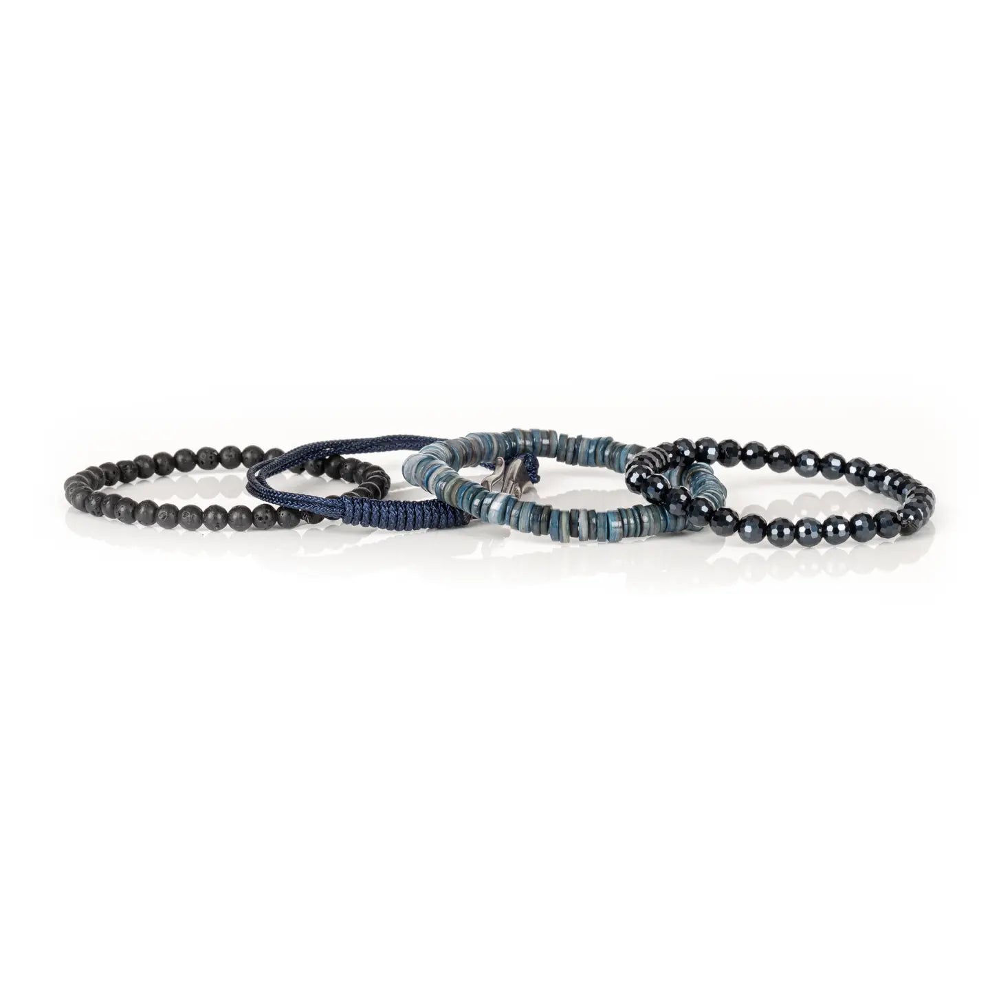 Men's layered bracelet set featuring faceted black crystal beads, blue heishi stone beads, navy woven cord, and matte black lava stone beads arranged in a stacked design on a white background.