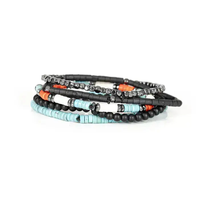 Black multi-layer men’s bracelet featuring hematite cube bead strands, matte black onyx beads, turquoise disc beads, and orange accent details on a light background.