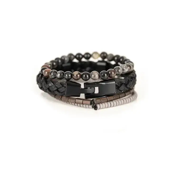 Black multi-layer men’s bracelet set featuring braided leather band, smoky grey natural stone beads, hematite cube accents, and layered metallic bead strands on a light background.