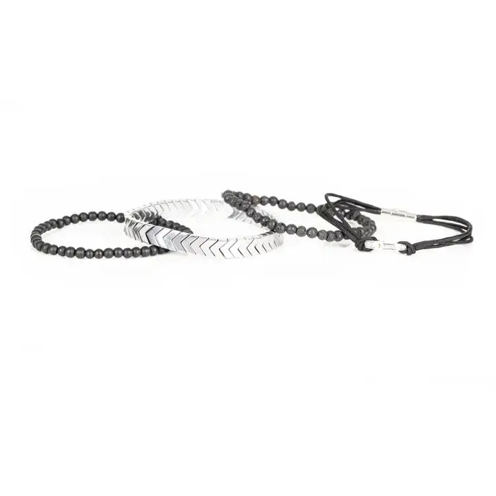 Black and silver layered men’s bracelet set with silver chevron metal strand, lava stone beads, matte black beads, and braided rope wraps on white background.