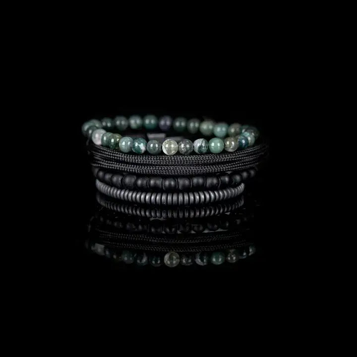 Green and black multi-layer men’s bracelet featuring natural green stone beads, braided black rope layers, matte black onyx beads, and gunmetal hematite disc strands on a light background.