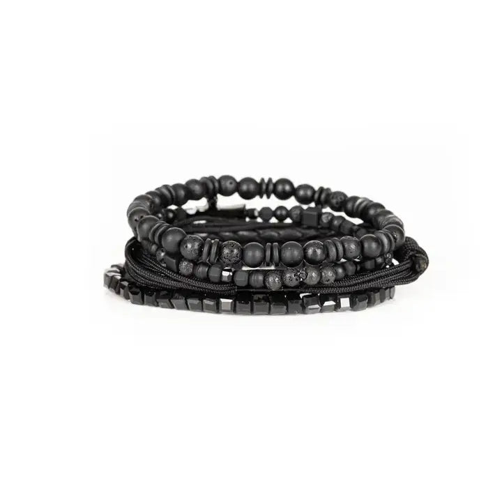 Black layered men’s bracelet set with lava stone beads, braided leather, rope wraps, faceted crystal accents, and pavé cross detail on white background