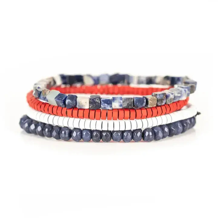 Blue, red, and white multi-layer men’s bracelet set featuring faceted blue beads, natural stone cube beads, and layered colorful disc bead strands on a light background.