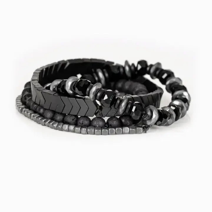 Men’s layered bracelet set featuring faceted black crystal beads, black and gray marbled stone beads, gunmetal chevron metal beads, matte black lava stone beads, and silver-tone hematite spacer beads, stacked in a bold monochromatic luxury design on a white background.