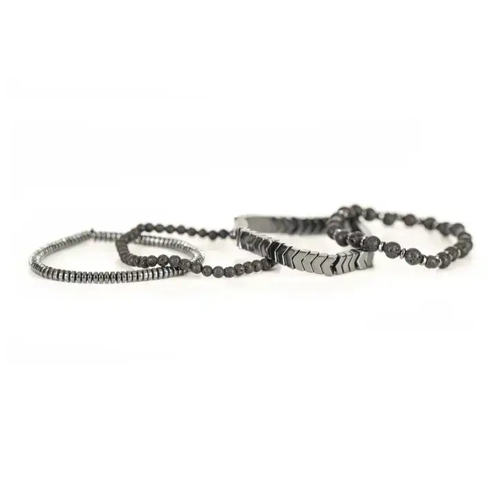 Black multi-layer men’s bracelet set featuring lava stone beads, silver chevron metal bar, hematite spacer beads, and layered metallic accents on a light background.