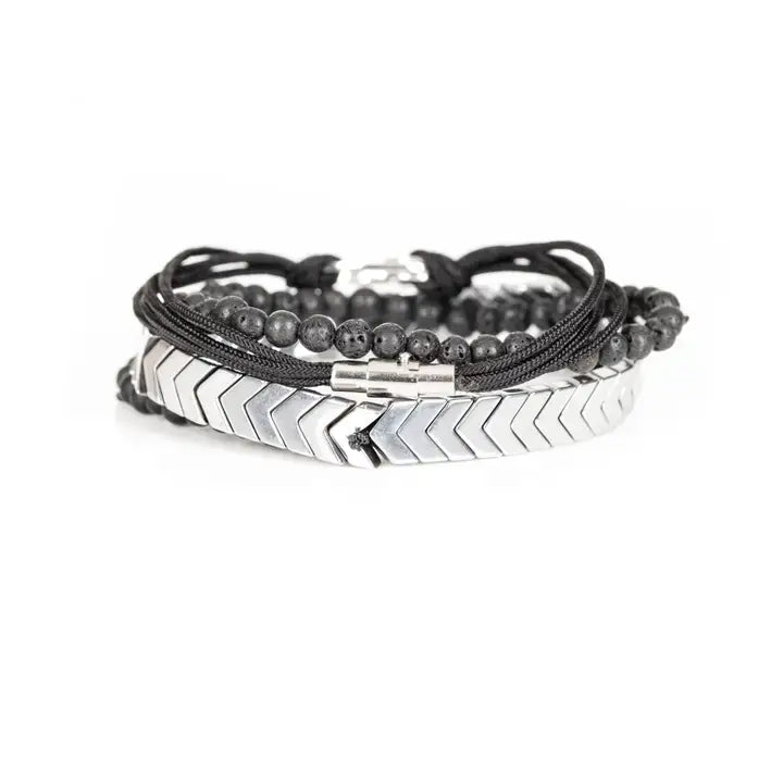 Black and silver layered men’s bracelet set with silver chevron metal strand, lava stone beads, matte black beads, and braided rope wraps on white background.