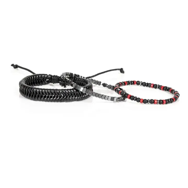 Black multi-layer men’s bracelet featuring glossy black disc beads, metallic hematite cube beads, matte black accents, and red bead details with adjustable cord closure on a light background.